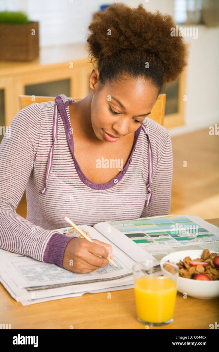 Woman Filling Out Crossword Puzzle And Having Breakfast Stock Photo Alamy